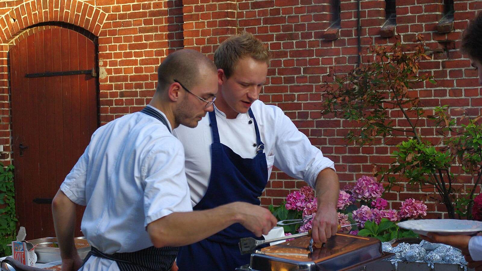 Köche bereiten Speisen im Freien vor.
