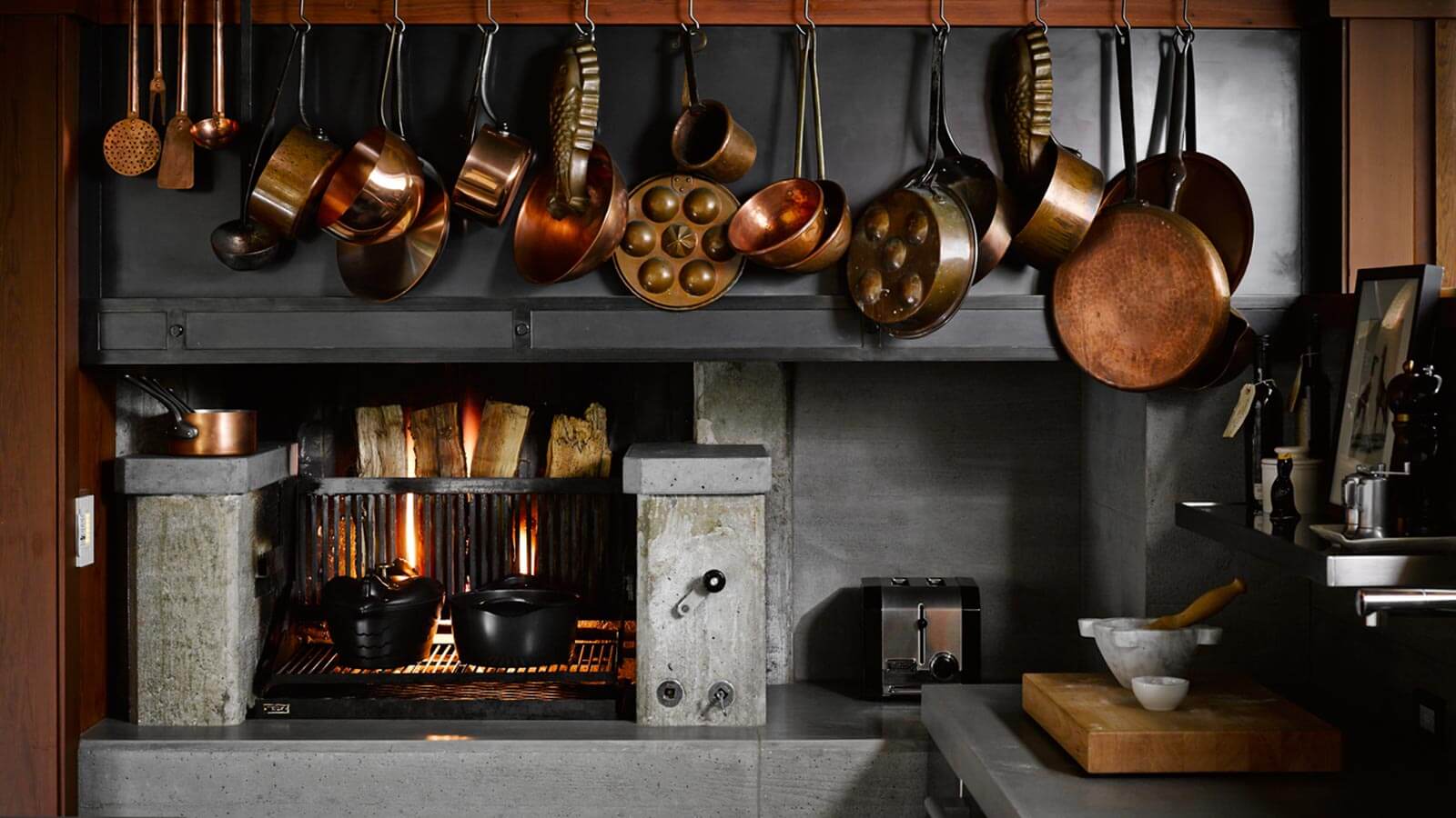 Moderne Küche mit Kupfergeschirr und Kamin.
